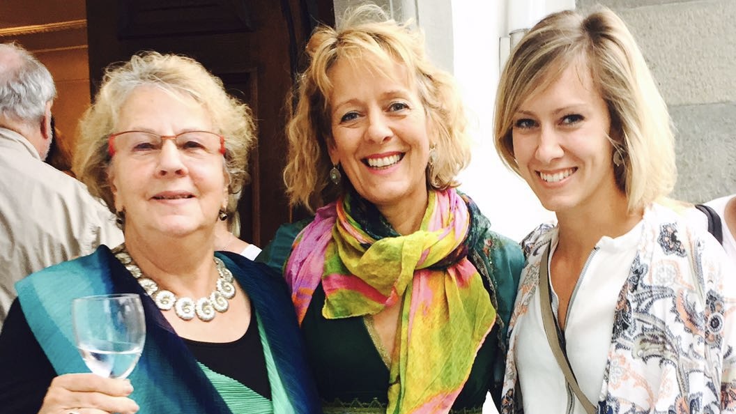 Claudia Fornito lacht mit zwei Frauen aus verschiedenen Generationen